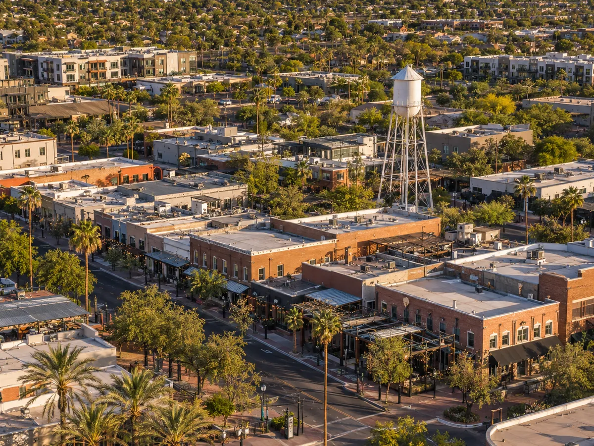 Aerial drone view of downtown Gilbert's Heritage District, Arizona, featuring its historic water tower and Main Street storefronts.